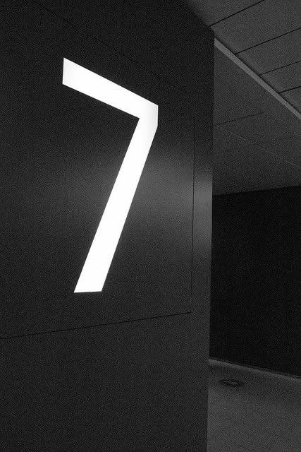Illuminated number seven on a dark wall
